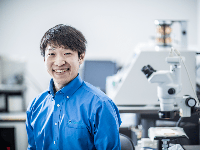 Scientist in front of microscope in cleanliness and microbiological analysis lab