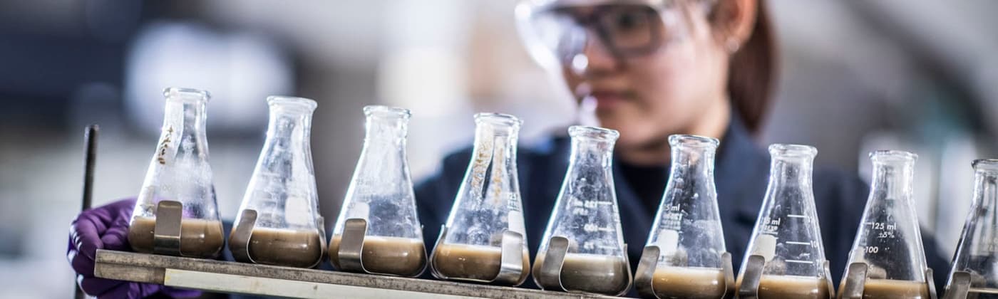 Element scientist studying soil testing samples in beakers