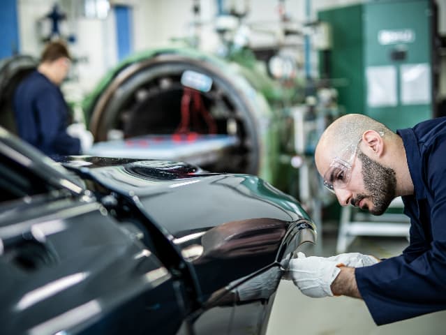 Testing engineer studying exterior panel of a car in testing lab