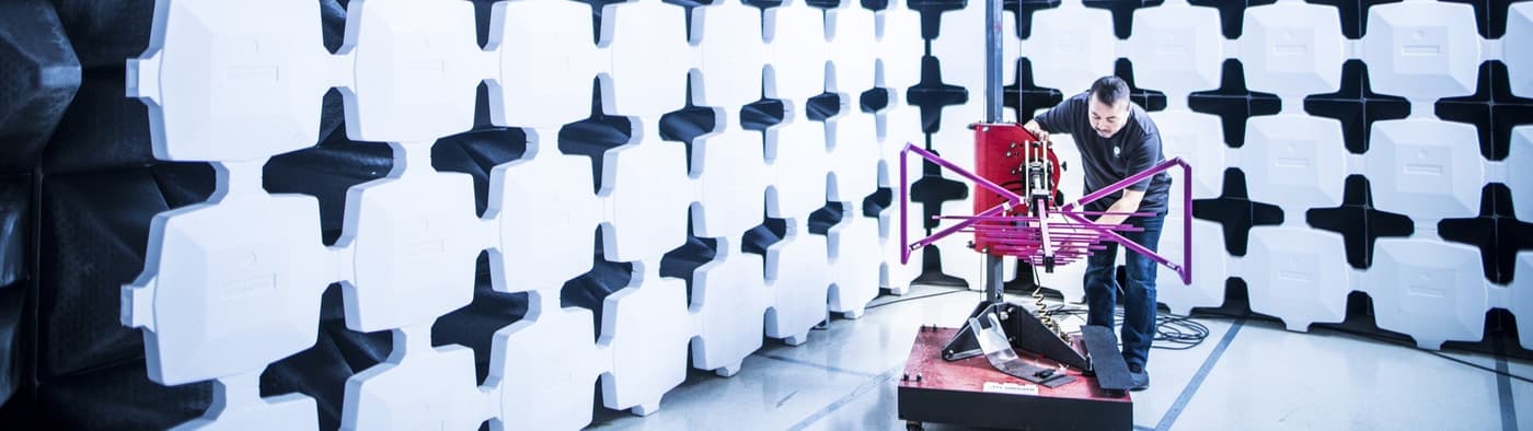Element test engineer calibrating equipment in an anechoic testing chamber