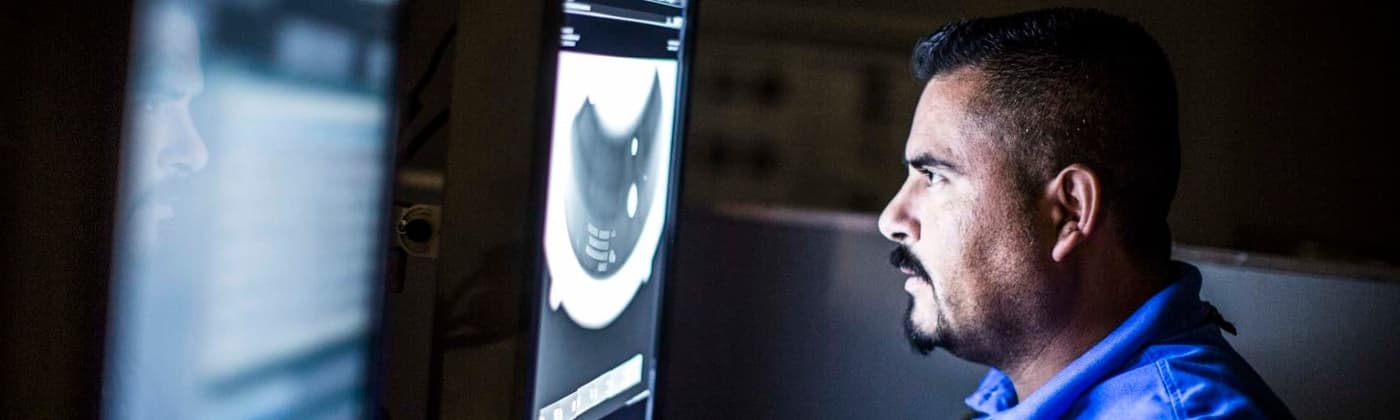 NDT testing engineer studying radiography scan in dark room