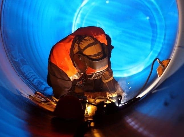 Welding professional welding in a subsea pipeline wearing protective equipment