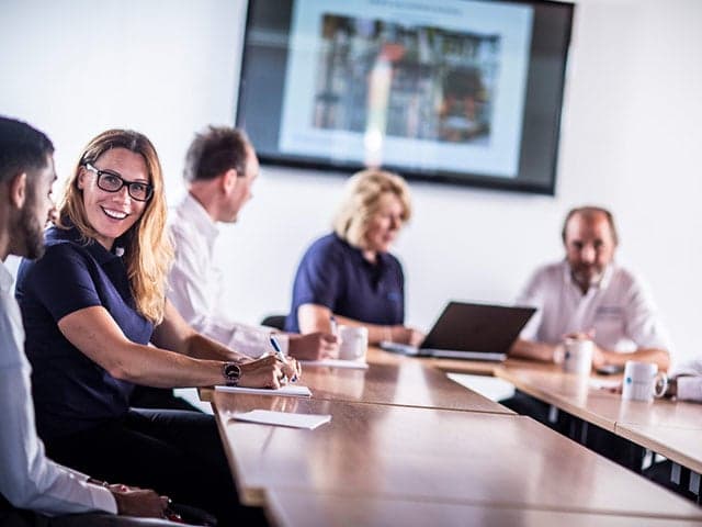Element colleagues conversing while seated at table in conference room