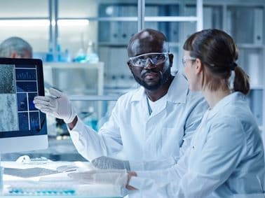 image of two scientists at a compter terminal discussing the data on screen