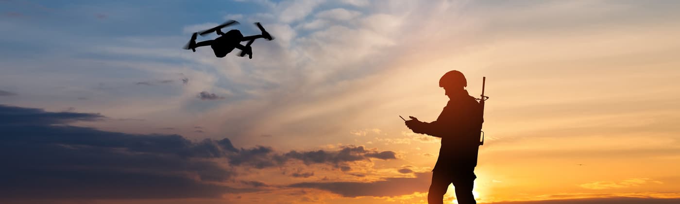 Service member in front of a sunset background operating drone  that has undergone military and aerospace component certification