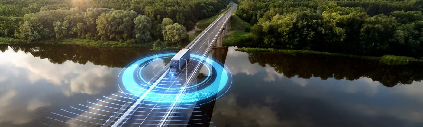 Autonomous truck with digital sensor overlay on bridge representing transportation testing and connected vehicle certification