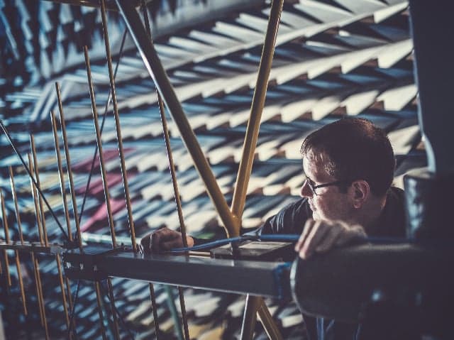 An engineer positioning test equipment inside an anechoic chamber lined with RF-absorbing foam panels.