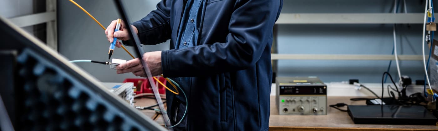 An Element engineer connecting cables to test equipment in a radio frequency testing laboratory.