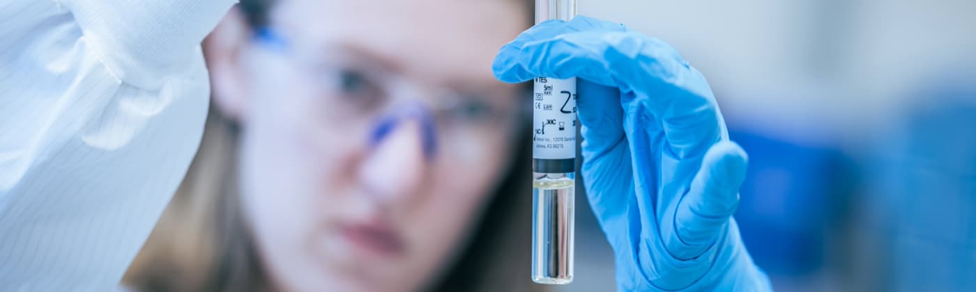 Pharmaceutical scientist examining AAV viral vector sample in laboratory