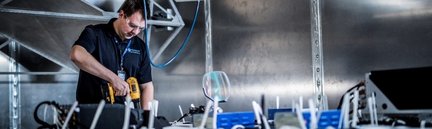 Engineer performing field uniformity calibration inside a reverberation chamber for EMI/EMC testing.
