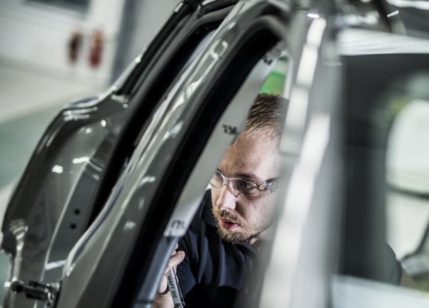 Testing engineer in a vehicle studying the window and trim in a testing laboratory