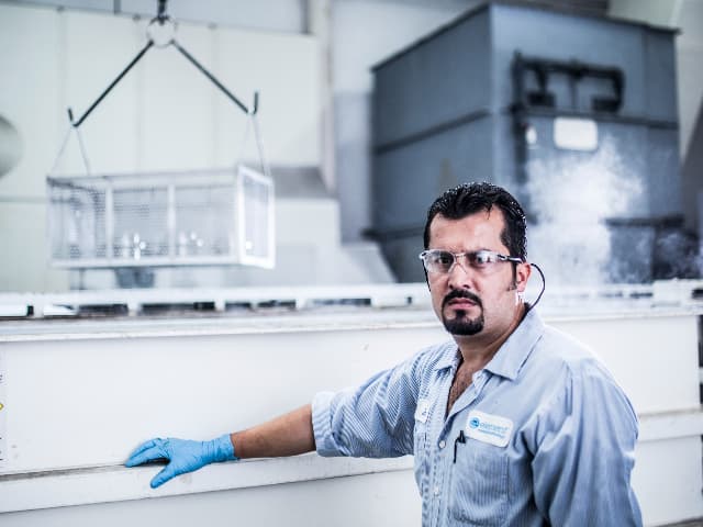 Element chemical processing engineer in front of tank.
