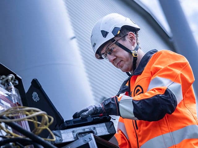 Technician operating equipment at industrial facility