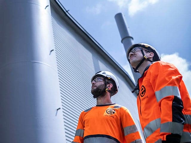 Technicians in safety gear at biogenic carbon emissions monitoring facility