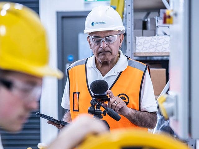 Safety specialist conducting COSHH risk assessment in industrial workplace