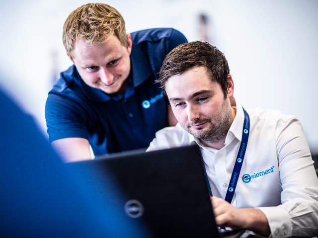 Two Element engineers reviewing UKCA certification test data on a laptop.