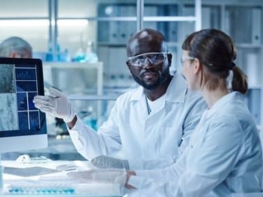 image of two scientists at a compter terminal discussing the data on screen