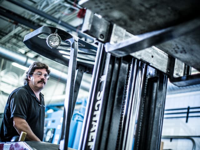 An engineer operating a large vibration test rig in a dynamics and vibration testing laboratory.