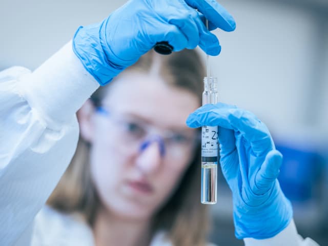 Pharmaceutical scientist examining AAV viral vector sample in laboratory