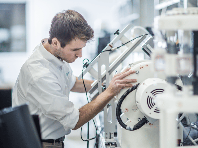 Element testing engineer operating testing equipment in materials and product testing lab