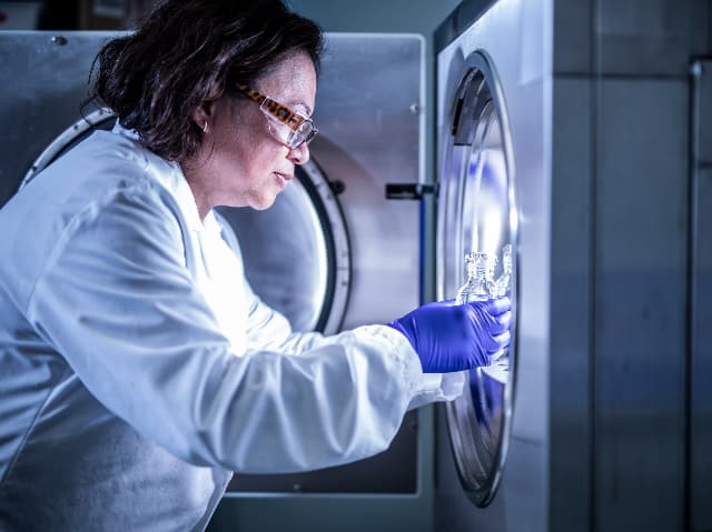 Element laboratory scientist placing raw materials sample in test chamber for controlled testing conditions